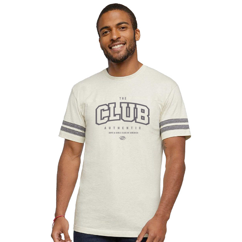 A man wearing a beige crew neck t-shirt with 'The Club' text and stripe details on the sleeves.