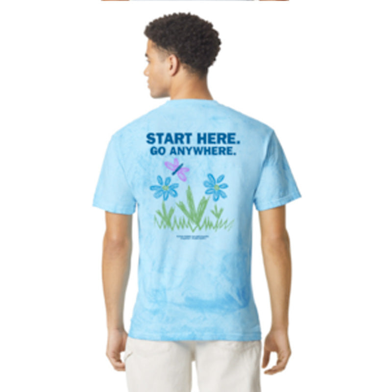 Back view of a person wearing a light blue tie-dye T-shirt with the words ‘Start Here. Go Anywhere.’ above a graphic of flowers and a dragonfly.